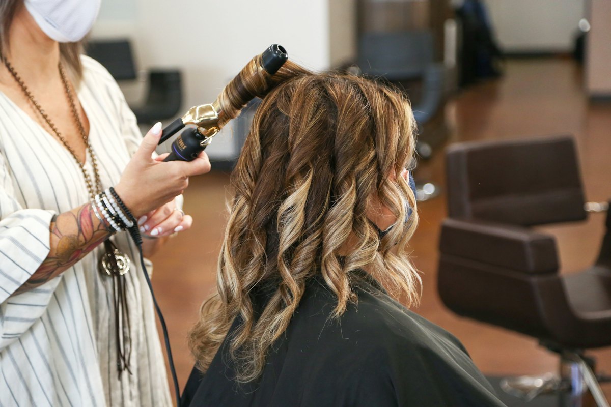 Friseurin stylt Locken